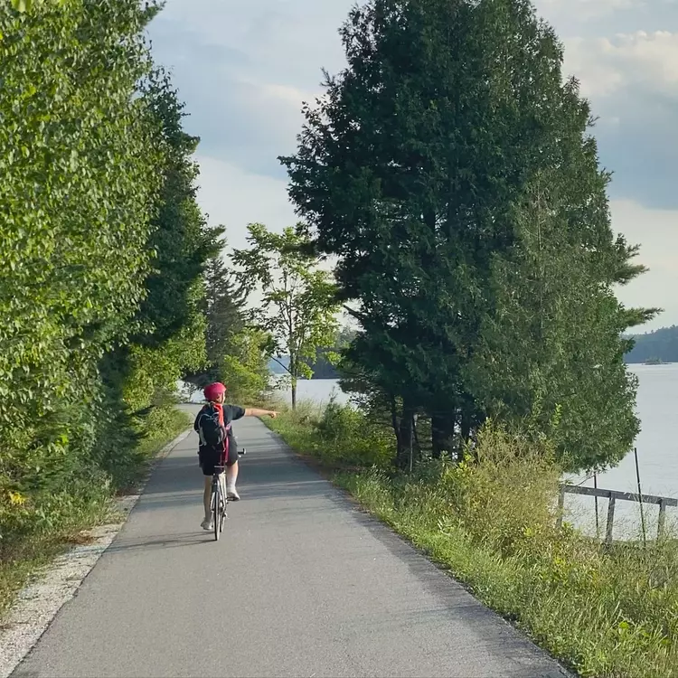 a person riding a bicycle on a path by a body of water