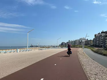 a person riding a bike on a path by the water