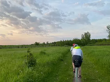 a person riding a bike on a grassy field