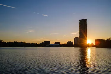 a body of water with buildings and trees in the background