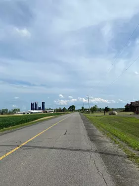 a road with grass and buildings on the side