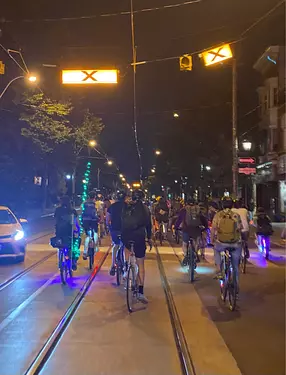 a group of people riding bicycles on a street at night
