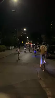 a group of people riding bicycles at night