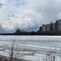 a frozen lake with buildings in the background