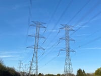 a person riding a bicycle on a path with power lines above them