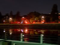 a body of water with a fence and trees around it