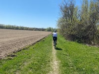 Nathan riding on a dirt path in a field