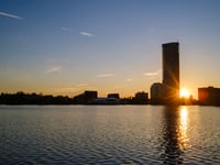 a body of water with buildings and trees in the background