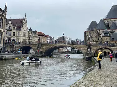 a boat sailing under a bridge