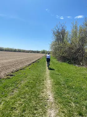 Nathan riding on a dirt path in a field