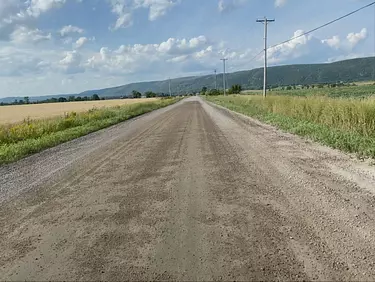 a dirt road with grass on either side of it