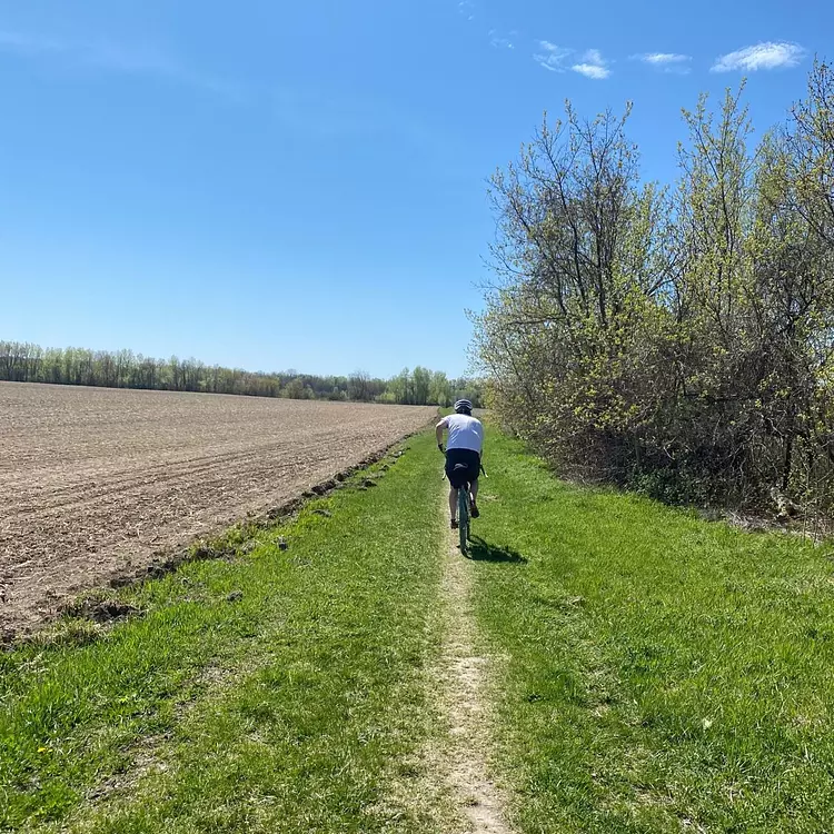 Nathan riding on a dirt path in a field