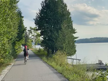 a person riding a bicycle on a path by a body of water