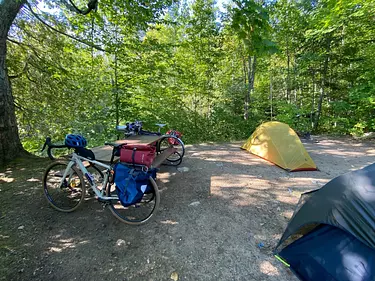 a bicycle and a tent in a forest