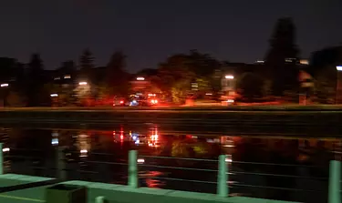 a body of water with a fence and trees around it