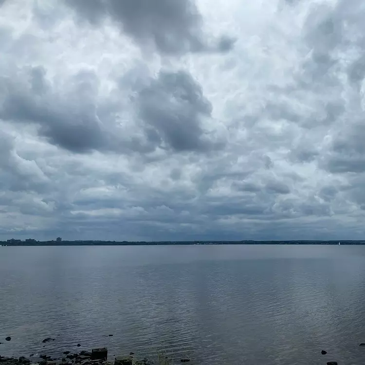 a body of water with clouds above it