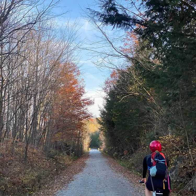 Kerianne riding her bicycle on a path surrounded by trees